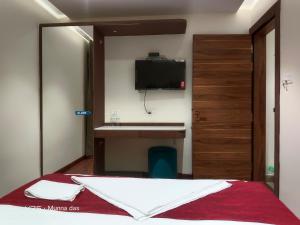 a bedroom with a bed and a tv on the wall at The Pride in Jamshedpur