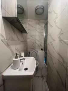 Baño blanco con lavabo y aseo en Islington Apartments, en Londres