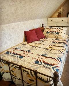 a bed with a quilt on it in a bedroom at Pansy’s Parlor Bed & Breakfast in Golden