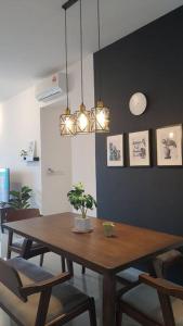 a dining room with a wooden table and chairs at Sensorizza @ Sensory Residence in Kampong Tangkas