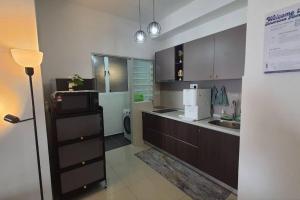 a kitchen with a sink and a microwave at Sensorizza @ Sensory Residence in Kampong Tangkas