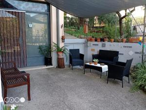 un patio con sillas, una mesa y una ventana en Happy Days B&B, en Giove