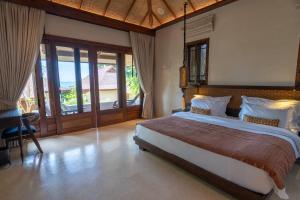 Schlafzimmer mit einem Bett, einem Schreibtisch und Fenstern in der Unterkunft Samed Tamarind Beach Resort in Ko Samed