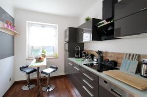 a kitchen with a counter and two bar stools at Apartment am Hutberg in Kamenz