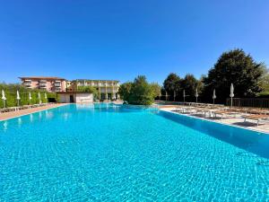 a large swimming pool with blue water at Hotel Bella Lazise in Lazise
