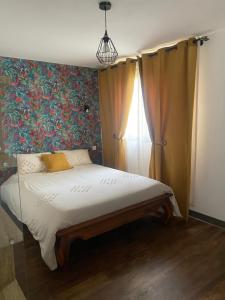 a bedroom with a bed with a floral wall at Le Palan in Saint-Pierre