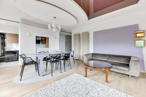 a living room with a table and chairs and a couch at CLASSY APARTMENTS - Gdynia - Słoneczne Wzgórze in Gdynia