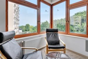 two chairs in a room with windows at CLASSY APARTMENTS - Gdynia - Słoneczne Wzgórze in Gdynia