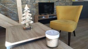 een woonkamer met een tafel en een stoel en een kerstboom bij TY BERNIC maison en Pierre, lumineuse, 2 à 4 pers à Riec Sur Belon in Riec-sur-Bélon
