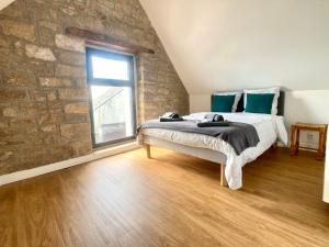 a bedroom with a bed and a brick wall at TY BERNIC maison en Pierre, lumineuse, 2 à 4 pers à Riec Sur Belon in Riec-sur-Bélon