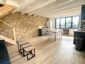 een kamer met een stenen muur en een tafel en stoelen bij TY BERNIC maison en Pierre, lumineuse, 2 à 4 pers à Riec Sur Belon in Riec-sur-Bélon