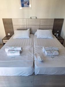 a bed with two towels and two pillows on it at Tassos 2 in Pefkochori