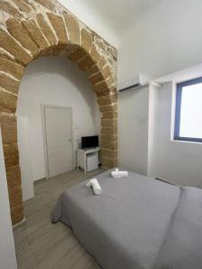 um quarto com uma cama e uma parede de tijolos em B&B A FACCI VISTA em Porto Empedocle