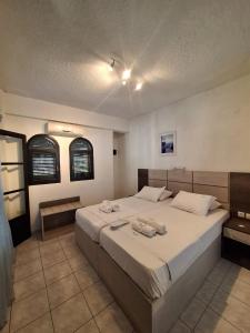 a bedroom with a large bed with two towels on it at Tassos 2 in Pefkochori
