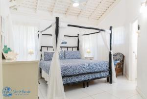 1 dormitorio con 1 cama con dosel en Sea Miracle Villa/Beach Cottage, en Silver Sands