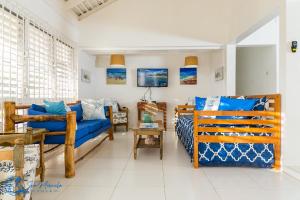 a living room with a blue couch and a bed at Sea Miracle Villa/Beach Cottage in Silver Sands