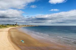 a beach with a view of the ocean and the sky at Spanish City View 1, Stylish Sea Front Apartment Free Onsite Parking in Whitley Bay