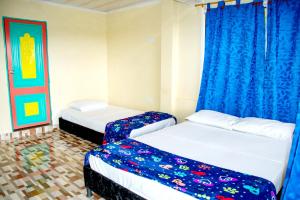 2 Betten in einem Zimmer mit blauen Vorhängen in der Unterkunft Finca hotel paraíso de Alcalá villa gilma in Alcalá