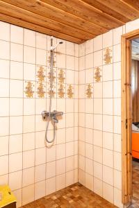 a shower in a bathroom with white tiled walls at Grandma Tyyne's home in Rovaniemi