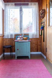 cocina con mesa, ventana y alfombra rosa en Grandma Tyyne's home, en Rovaniemi