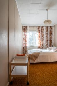 a bedroom with a bed and a window and a table at Grandma Tyyne's home in Rovaniemi