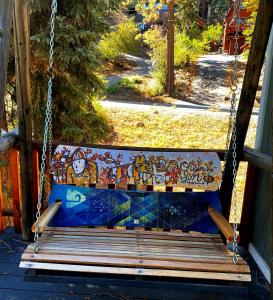 a swing on a porch with a mural on it at Hallelujah Forest in Big Bear Lake
