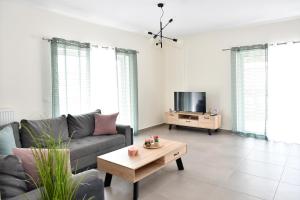 a living room with a couch and a tv at 90° - Ninety Degrees in Nafplio