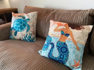 Un sofá con dos almohadas y una tortuga de mar. en Seaside - a75754 en Bovenkarspel