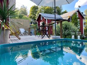 a house with a pool and a red shed at Torppa, puusauna ja ulkoporeallas in Lahti