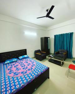 1 dormitorio con 1 cama y ventilador de techo en Ashirwad Homestay, en Dibrugarh
