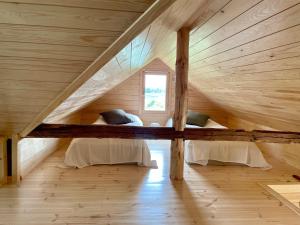 an attic room with two beds and a window at Kaivotontin torppa in Lahti