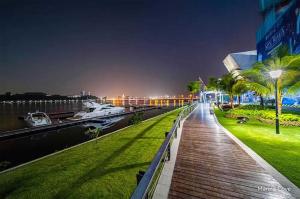 a wooden walkway next to a river at night at Pleasant and Cozy 3BR Suit @ R&F Mall Johor Bahru in Johor Bahru
