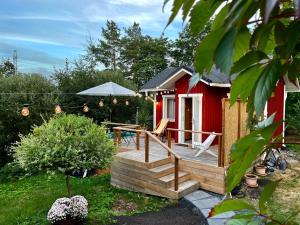 een rood tiny house met een houten terras bij Kaivotontin torppa in Lahti