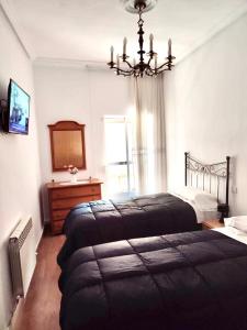 a bedroom with two beds and a chandelier at Libertad, 1 in Zamora