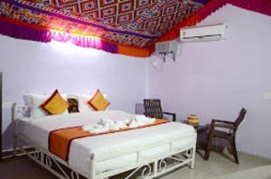 a bedroom with a bed with a colorful ceiling at Ozaki Desert Camp & Resort in Jaisalmer