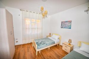 ein kleines Schlafzimmer mit einem Bett und einem Fenster in der Unterkunft Villa Alba in Shkodra