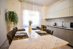 a kitchen with a table with chairs and a counter top at Villa Alba in Shkodër