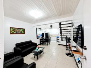 een woonkamer met een bank en een tafel bij Calapan City Cheapest House Transient Guest Rental L39 in Calapan