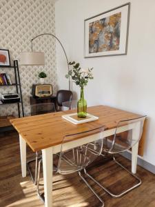 una mesa de comedor con un jarrón encima en Gîte Homard - Bord de mer - 4/6 personnes, en Quinéville 15 fotos más