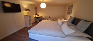 a bedroom with a large white bed with white pillows at Schöne ruhige Eigentumswohnung mit Terrasse in Flensburg