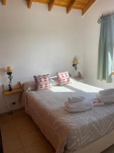 um quarto com uma cama com toalhas em El Abrigo em El Calafate