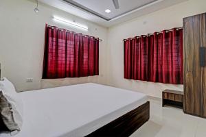 een slaapkamer met rode gordijnen en een groot bed bij Hotel Midway Treat Dhar in Dhār