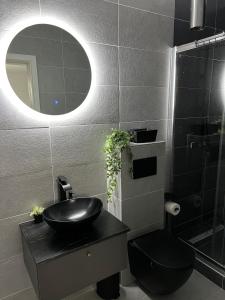 a black bathroom with a sink and a mirror at Villa in Domnești in Domneşti