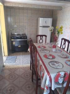 uma cozinha com uma mesa, um frigorífico e um fogão em Casa Santa Ana, Bananeiras PB em Bananeiras