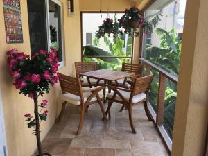 stół i krzesła na balkonie z kwiatami w obiekcie Just Chillin in Little Cayman w mieście Head of Bay
