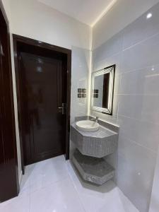 a bathroom with a sink and a mirror at شقق الايام المضيئة المخدومة in Najran