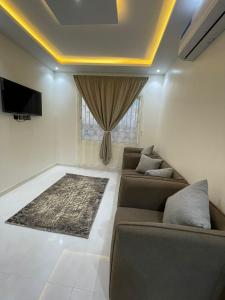 a living room with two couches and a tv at شقق الايام المضيئة المخدومة in Najran