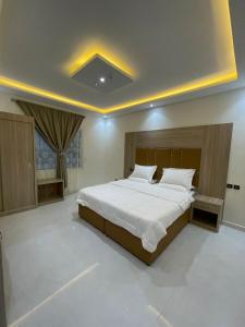 a bedroom with a large bed in a room at شقق الايام المضيئة المخدومة in Najran