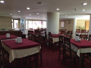 uma sala de jantar com mesas e cadeiras com toalha de mesa vermelha em Ilıcak Hotel em Istambul