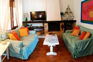 Una sala de estar con dos sofás y un televisor. en l'ibiscus, en Brucoli